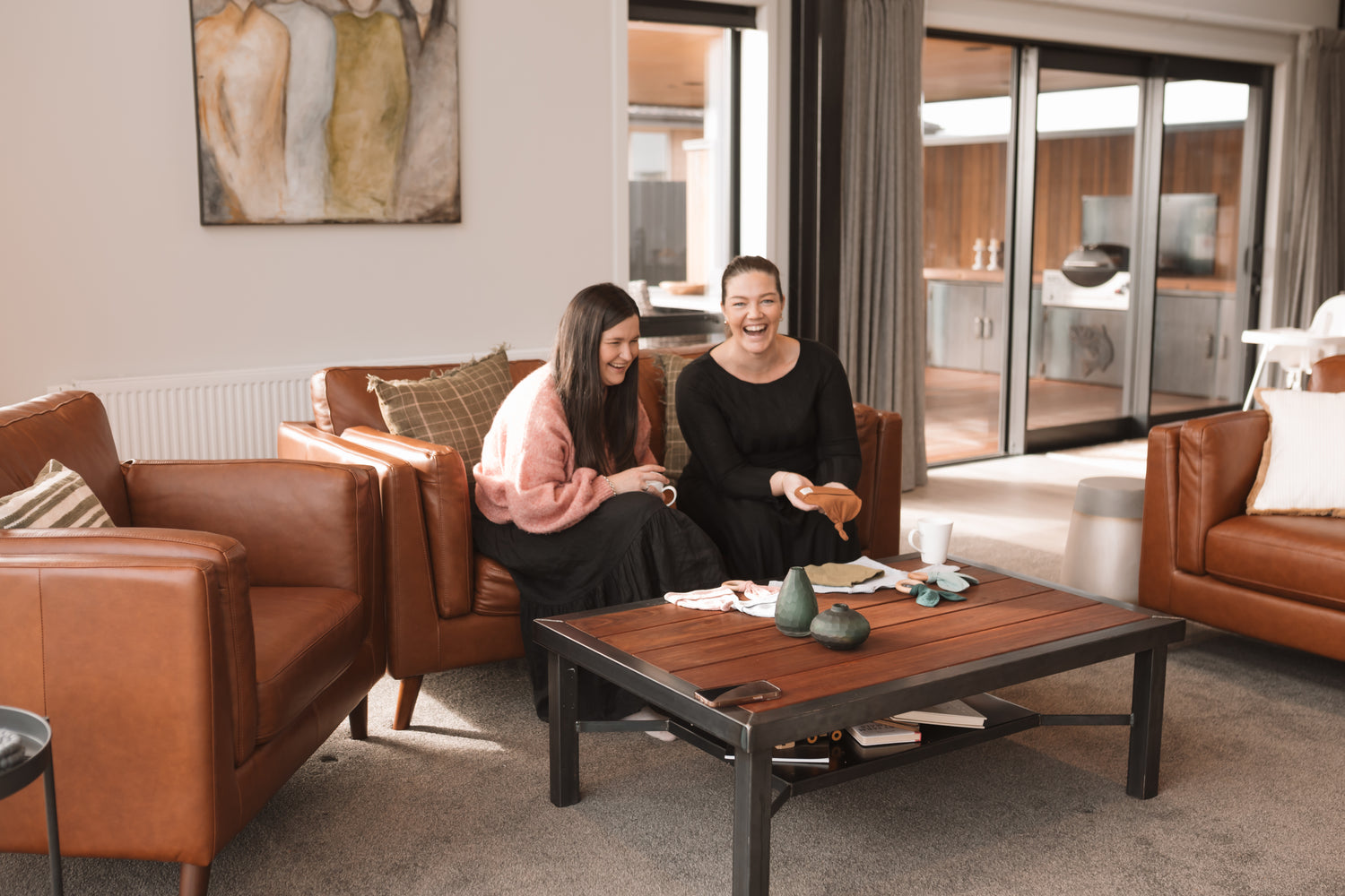Owners of Staple Baby sitting on couch with organic baby clothing